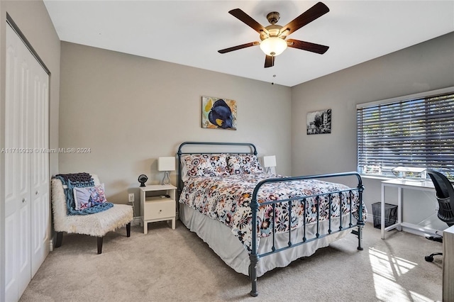 bedroom with light colored carpet, a closet, and ceiling fan