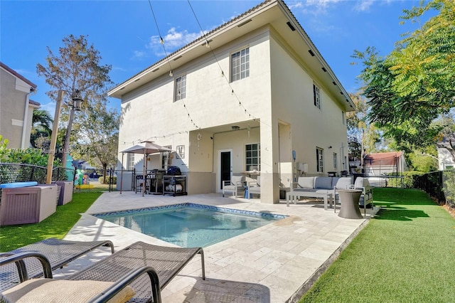 rear view of property with a lawn, a patio area, and a fenced in pool