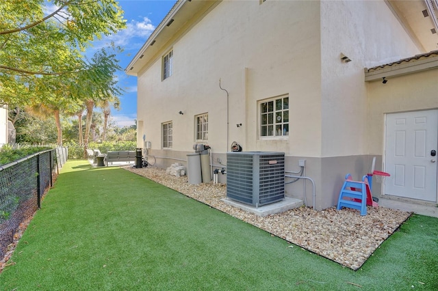 rear view of house featuring a yard, an outdoor living space, and central AC unit