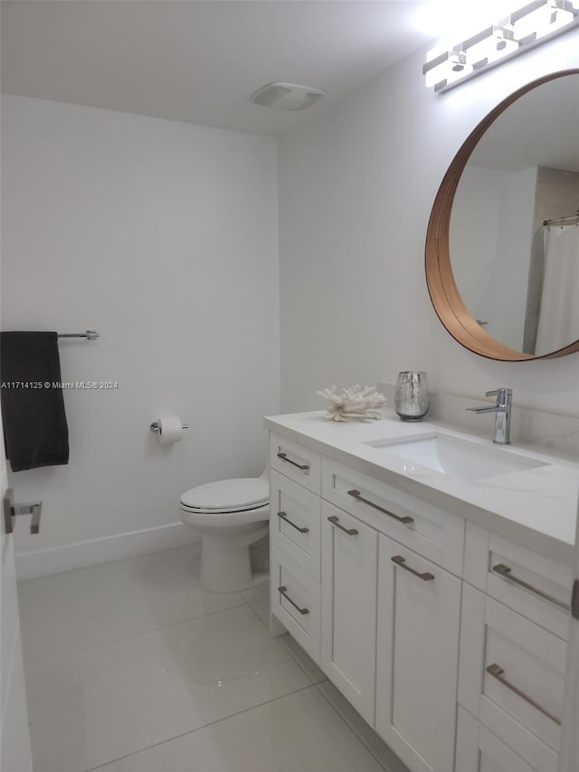 bathroom with tile patterned flooring, vanity, and toilet