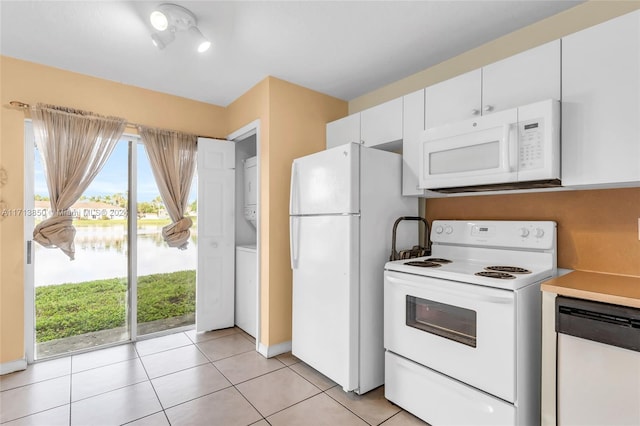 kitchen with white cabinetry, a water view, white appliances, and light tile patterned floors