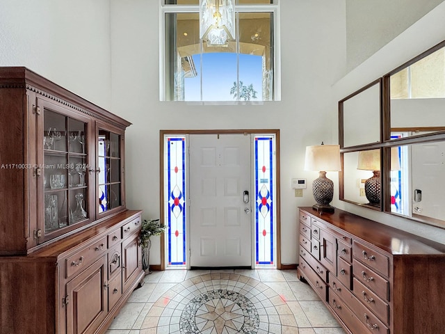 tiled entryway featuring a towering ceiling