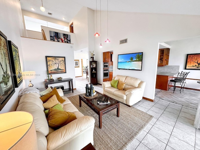 living room featuring light tile patterned floors and high vaulted ceiling