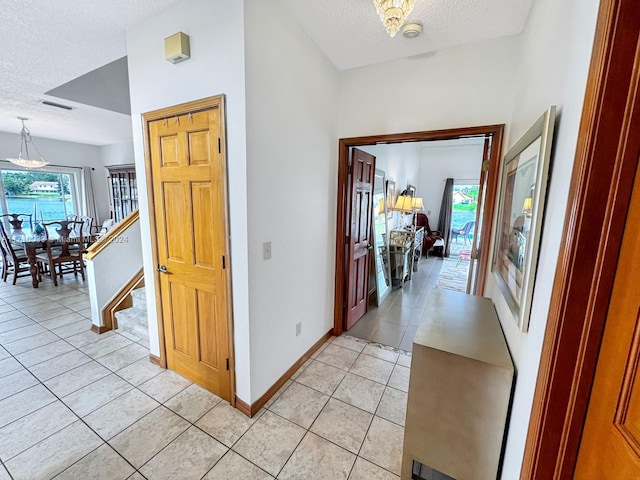 hallway with light tile patterned flooring and a textured ceiling