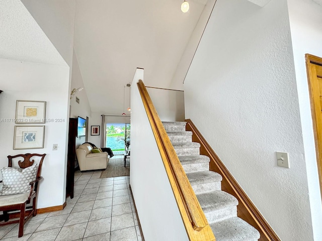 staircase with tile patterned floors and lofted ceiling