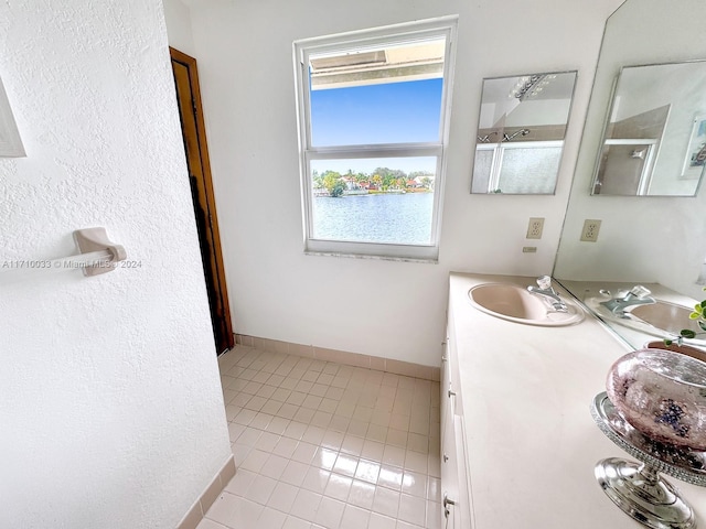 bathroom featuring tile patterned floors, vanity, and a water view