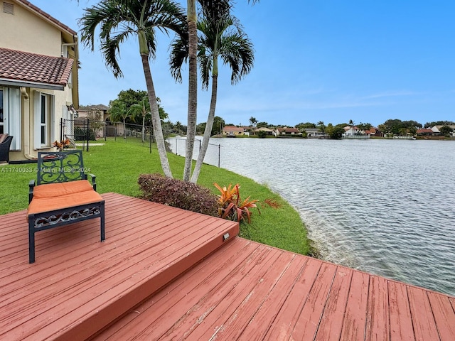 view of dock with a deck with water view and a yard