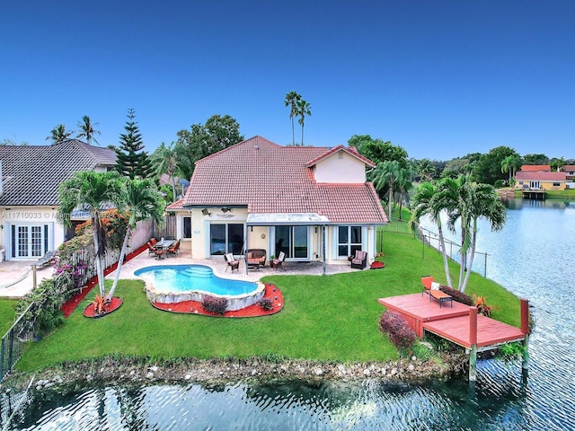 back of property with a fenced in pool, a patio area, a yard, and a water view