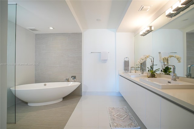 bathroom with tile patterned floors, vanity, tile walls, and a washtub