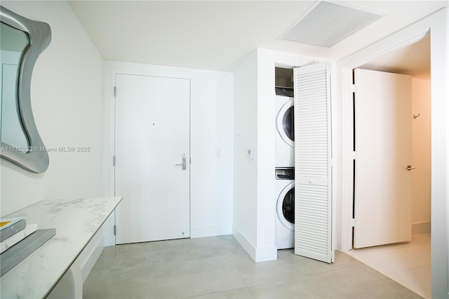 laundry room featuring stacked washer / drying machine