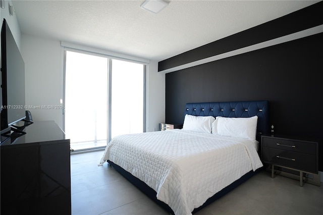 bedroom with a textured ceiling and floor to ceiling windows