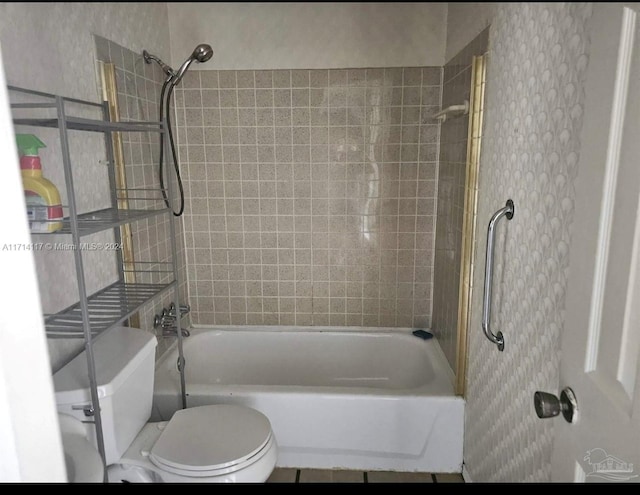 bathroom featuring tiled shower / bath and toilet