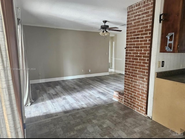 unfurnished living room with ceiling fan, a textured ceiling, and dark wood-type flooring