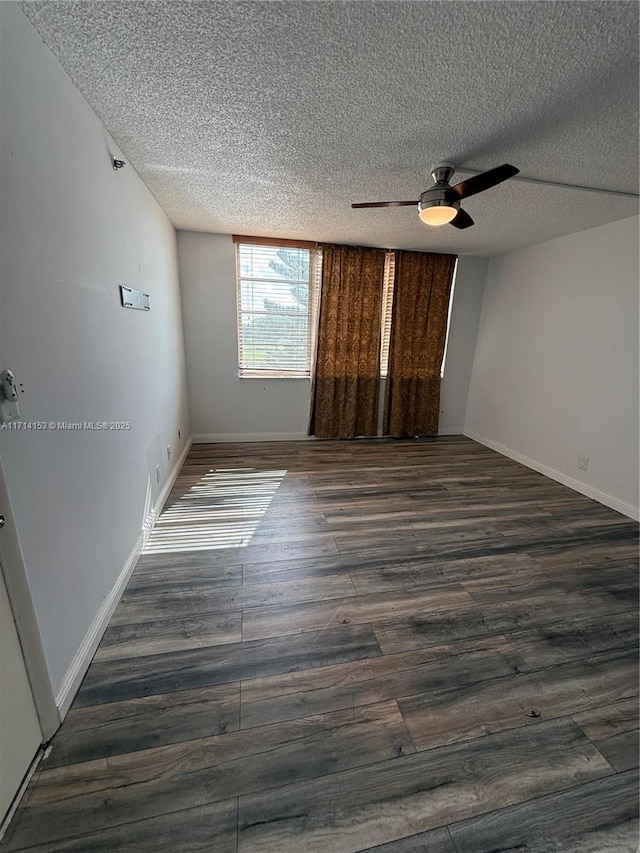 unfurnished room with baseboards, a textured ceiling, wood finished floors, and ceiling fan