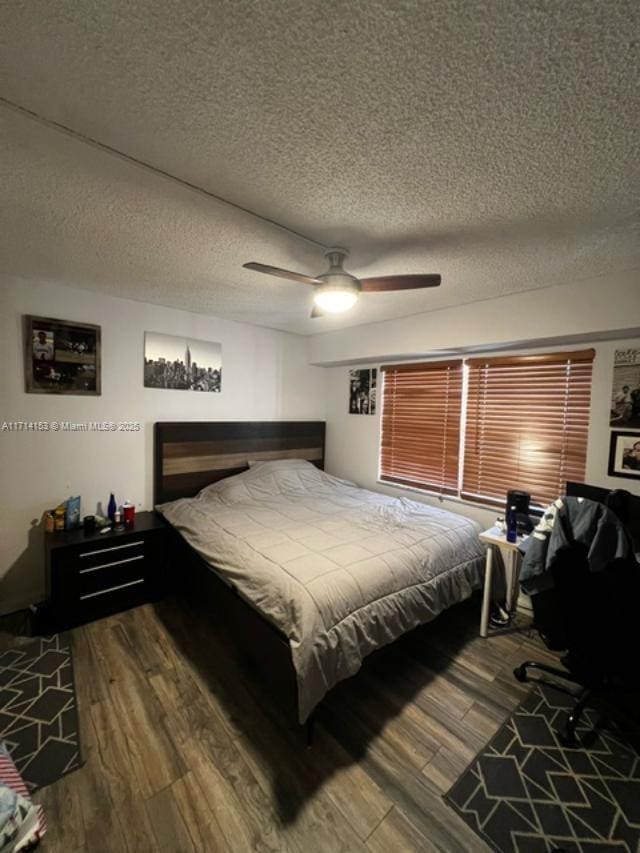 bedroom featuring a textured ceiling, wood finished floors, and ceiling fan