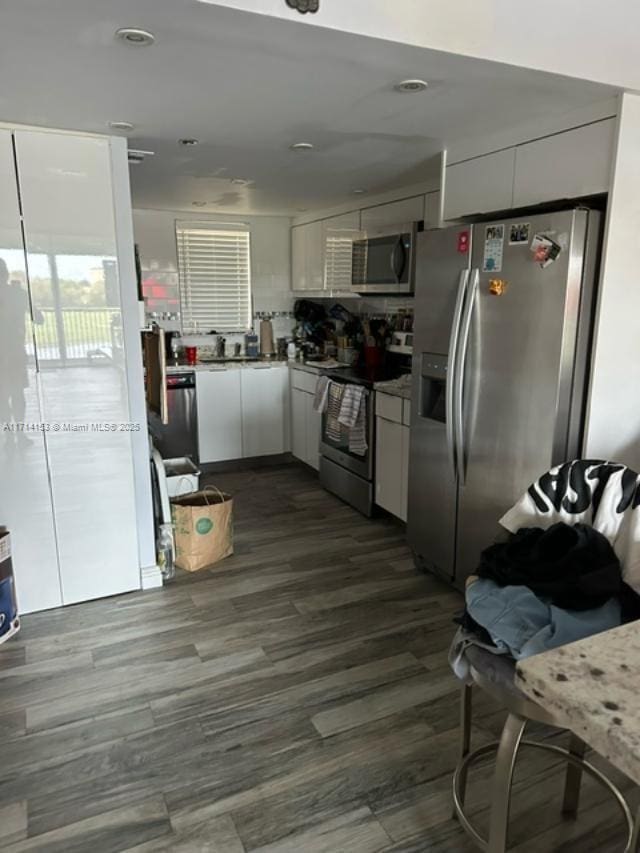 kitchen with white cabinetry, dark hardwood / wood-style flooring, and stainless steel appliances