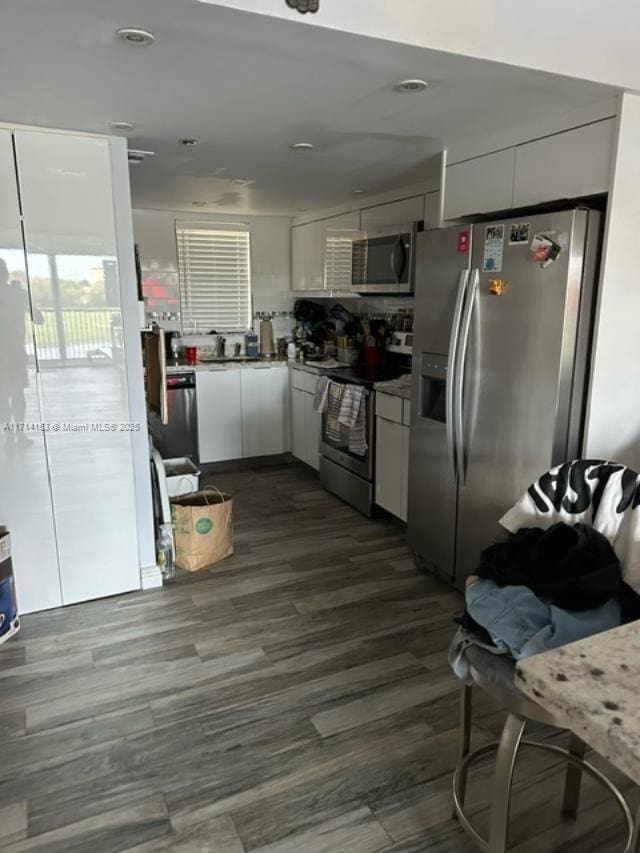 kitchen with white cabinets, appliances with stainless steel finishes, recessed lighting, and dark wood-style floors