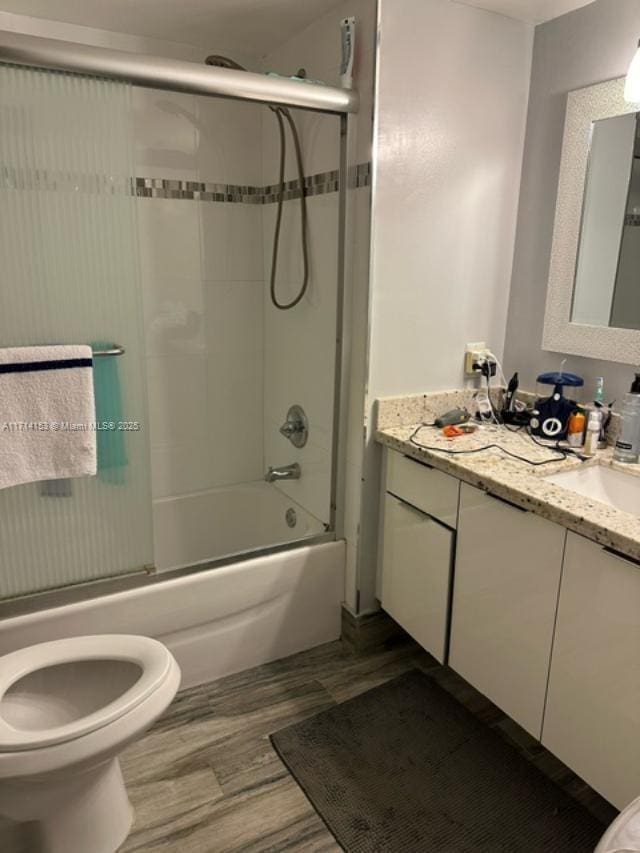 full bathroom featuring toilet, vanity, and combined bath / shower with glass door