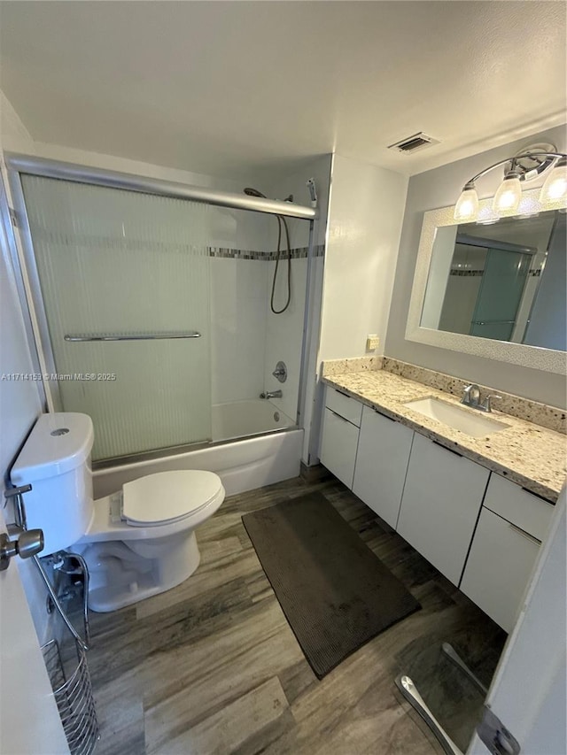bathroom featuring visible vents, toilet, vanity, and wood finished floors