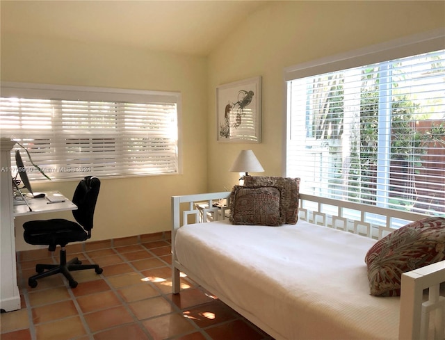 bedroom featuring vaulted ceiling, tile patterned floors, and multiple windows