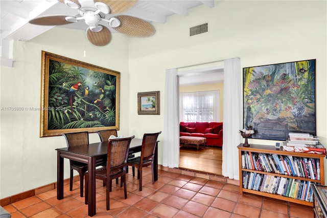 dining space with tile patterned floors, ceiling fan, and beam ceiling