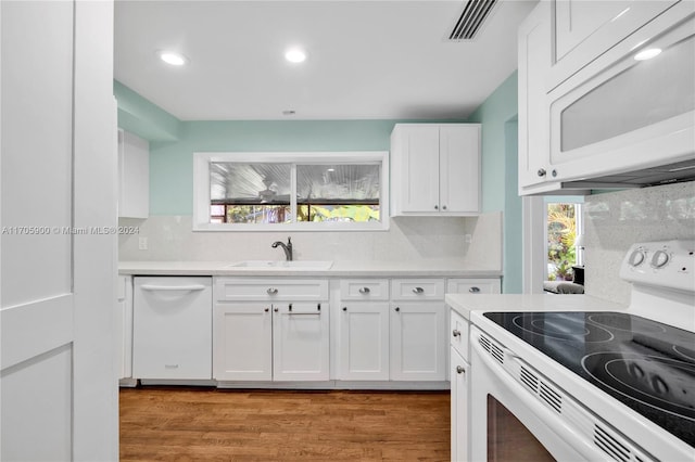 kitchen featuring white cabinets, light hardwood / wood-style floors, white appliances, and sink