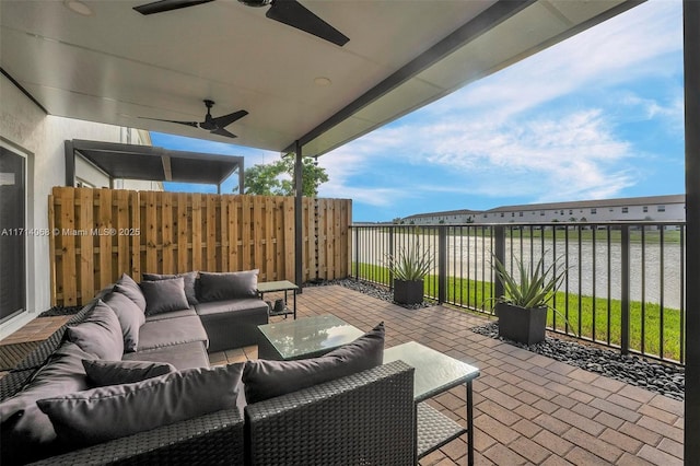 view of patio with a water view, outdoor lounge area, and ceiling fan