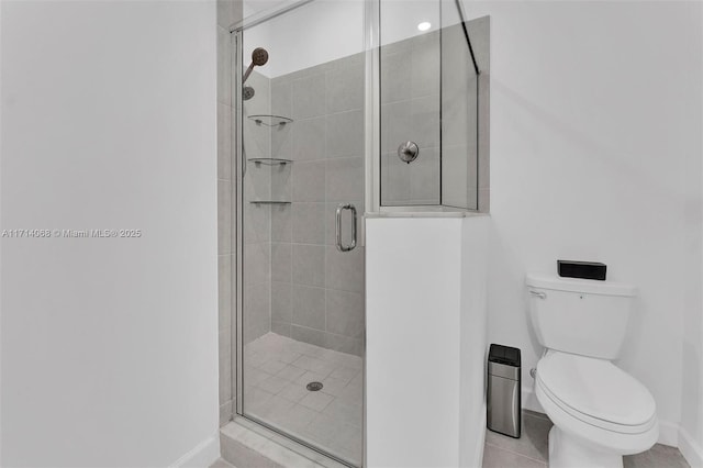 bathroom featuring tile patterned flooring, a shower with door, and toilet