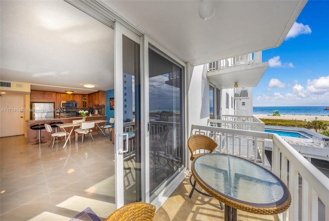 balcony featuring a water view and a view of the beach