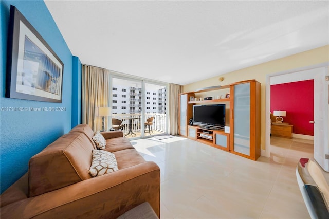 living room featuring light tile patterned flooring and a wall of windows