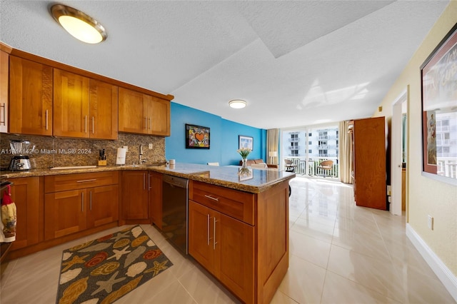 kitchen with backsplash, light tile patterned floors, black dishwasher, light stone counters, and kitchen peninsula