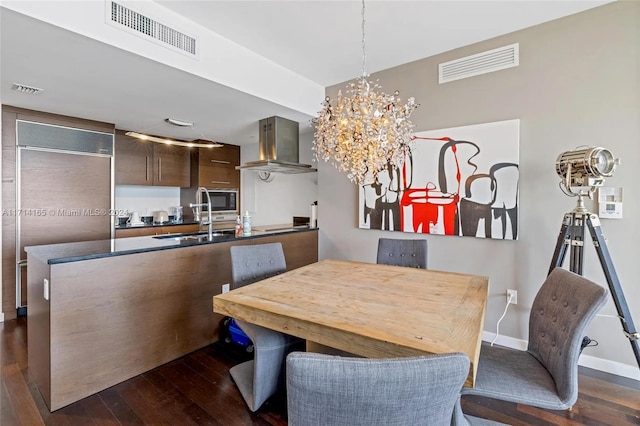 dining area featuring a chandelier, dark hardwood / wood-style flooring, and sink