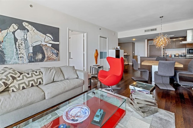 living room with hardwood / wood-style flooring and a notable chandelier