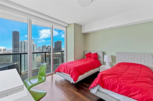 bedroom featuring hardwood / wood-style flooring and a wall of windows