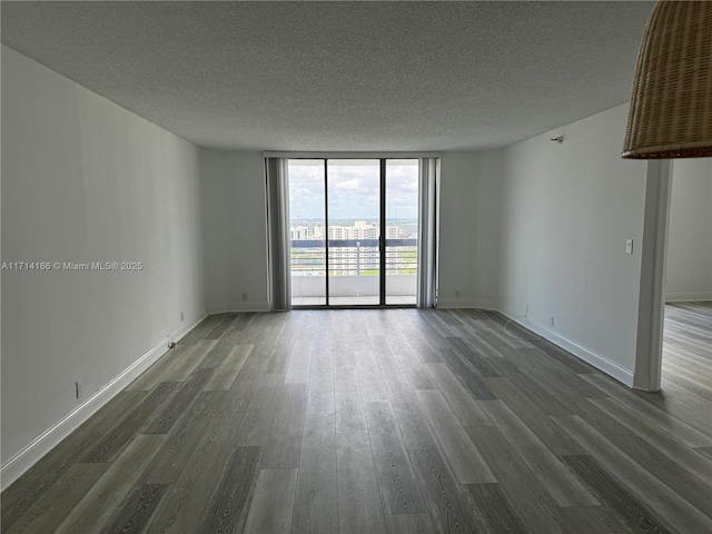 3530 Mystic Pointe Dr Unit 2602, Aventura, FL 33180 - empty room featuring a wall of windows, a textured ceiling, and dark wood-type flooring