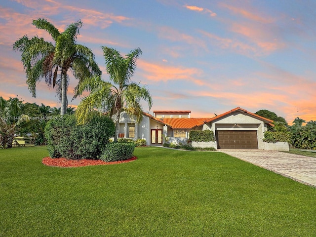 view of front of house with a garage and a lawn