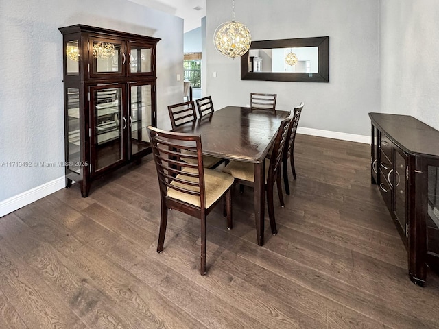 dining area with dark wood-type flooring and a notable chandelier