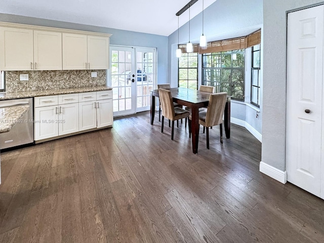 dining room featuring dark wood-type flooring, vaulted ceiling, and french doors