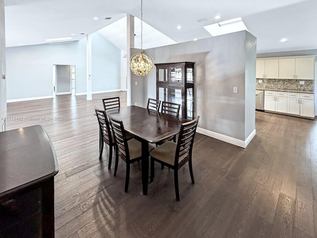 dining area featuring lofted ceiling with skylight, dark hardwood / wood-style flooring, and a notable chandelier