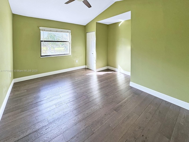 unfurnished room with dark wood-type flooring, ceiling fan, and vaulted ceiling