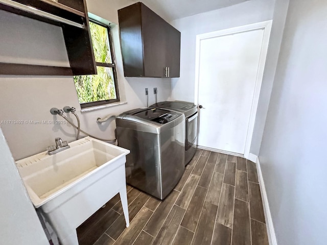 laundry room with sink, washing machine and dryer, and cabinets