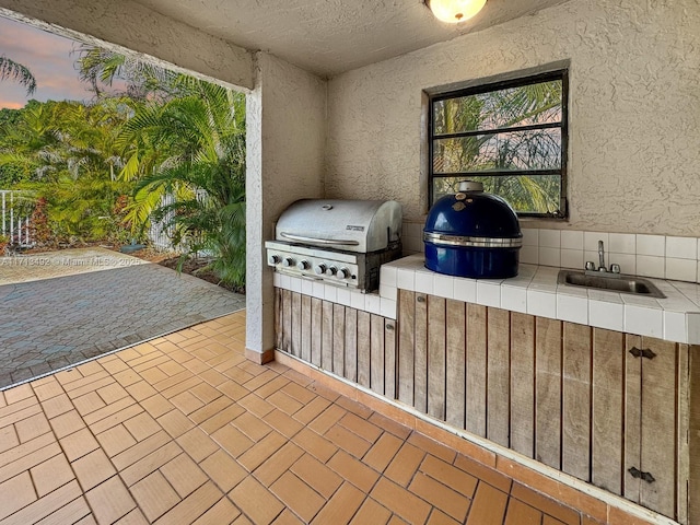 patio terrace at dusk with area for grilling and sink