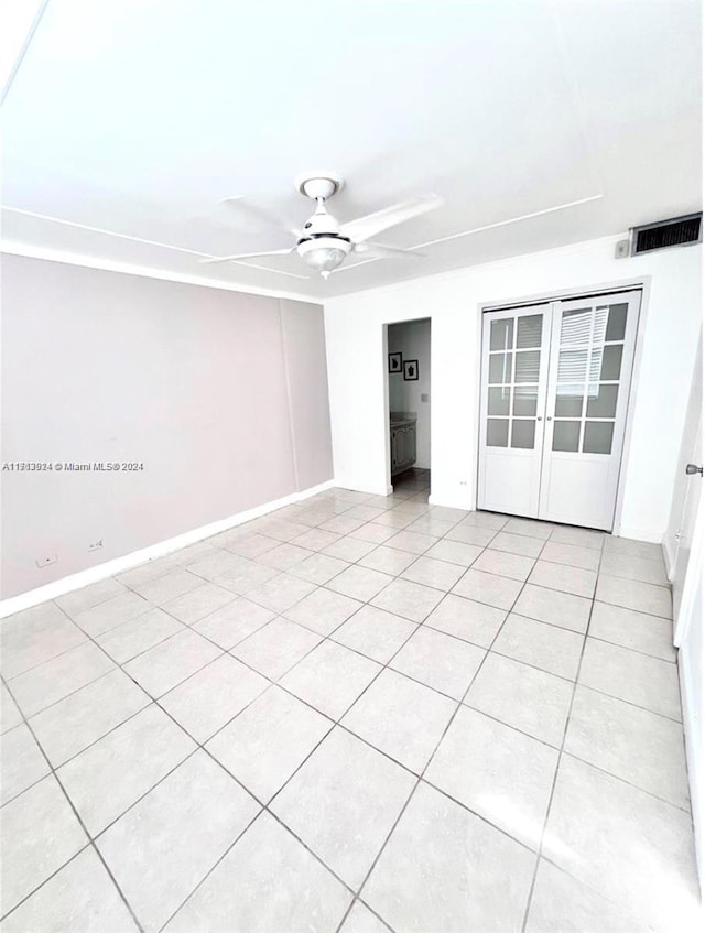 empty room featuring light tile patterned floors and ceiling fan