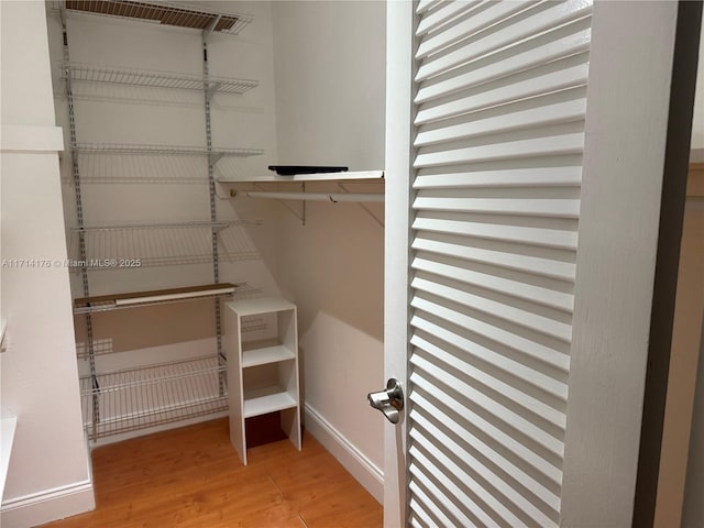 walk in closet featuring hardwood / wood-style flooring and radiator heating unit