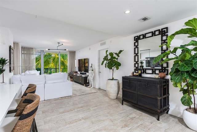 living room with expansive windows and light hardwood / wood-style floors