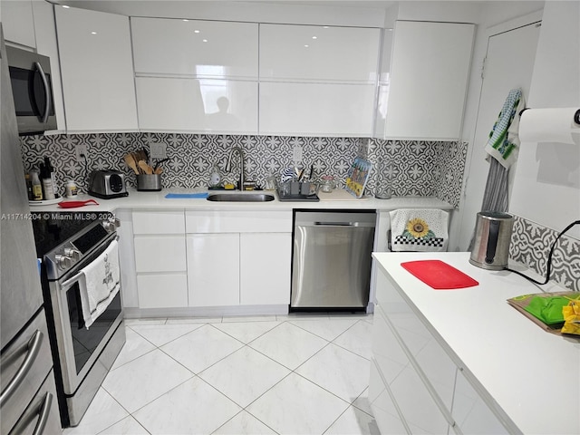 kitchen with white cabinets, sink, appliances with stainless steel finishes, and tasteful backsplash