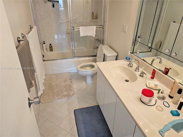 full bathroom featuring tile patterned flooring, toilet, combined bath / shower with glass door, and vanity