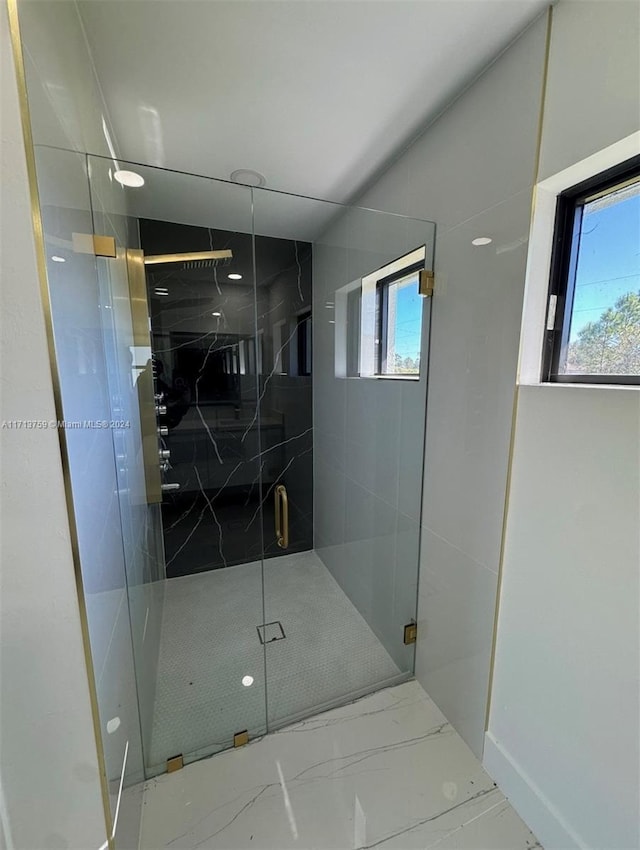 bathroom featuring a shower with door and a healthy amount of sunlight