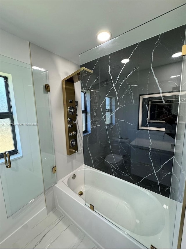 bathroom with combined bath / shower with glass door