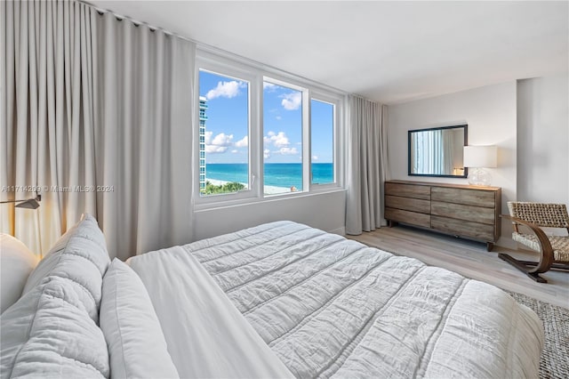 bedroom featuring a water view and light hardwood / wood-style flooring